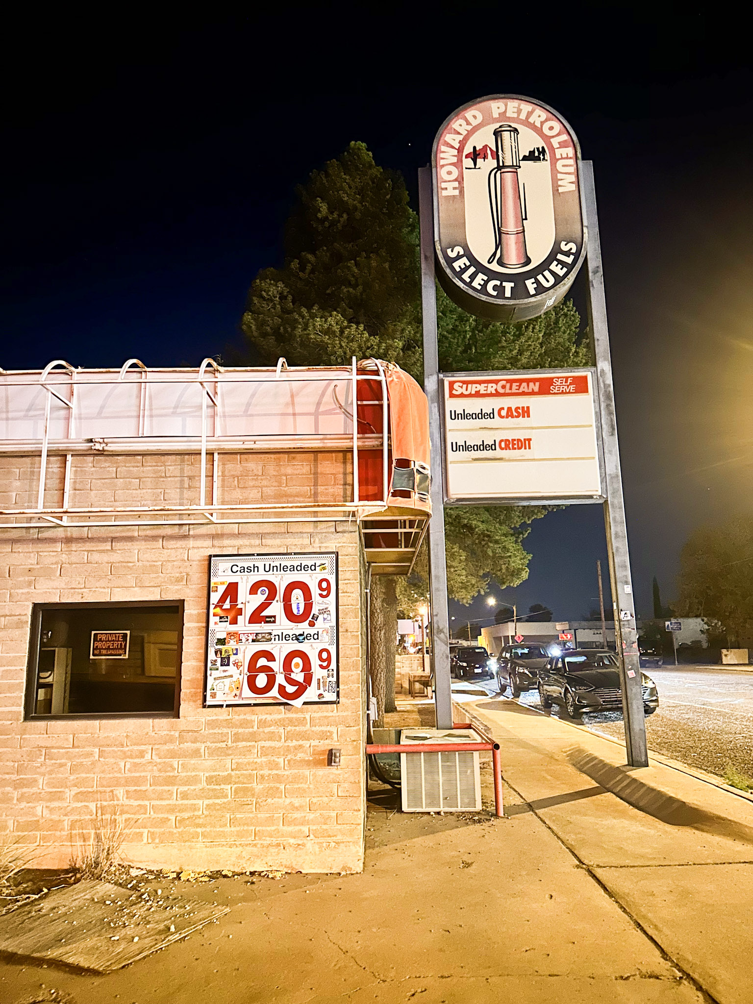 Howard Petroleum sign glowing in the night, with a playful $4.20 gas price display